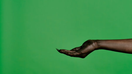 Creepy halloween devil monster hand in black paint with nails shows cupped palm, isolated on chroma key green screen background, workspace mockup.の写真素材
