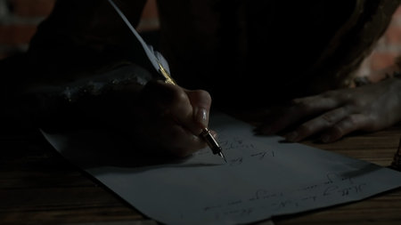 Antique young woman in renaissance dress sitting writing letter with vintage quill pen with ink on...