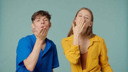 Positive couple of young boyfriend and girlfriend in yellow blue clothes isolated on green...