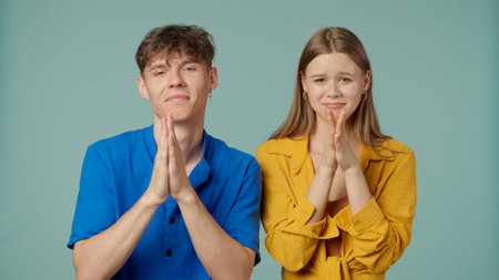 Positive couple of young boyfriend and girlfriend in yellow blue clothes isolated on green...