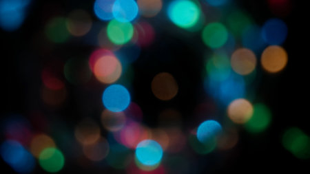 Blurred rainbow colored lens flare motion studio lightning, garland with bokeh effect on black background. Light leaks shining, abstract background footage.の写真素材