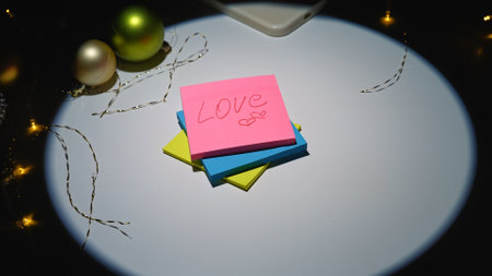 Close up shot of christmas decorated table under spotlight, group of colorful sticky memo notes with...