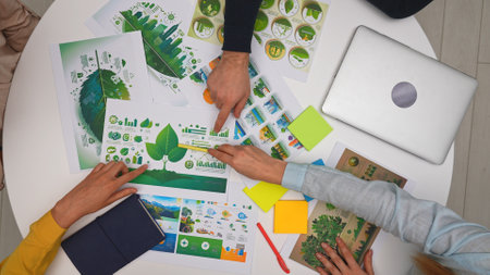 Top view creative project team meeting in boardroom sitting at desk, discussing ecological project, presenting visual concept graphics and corporate identity.の写真素材