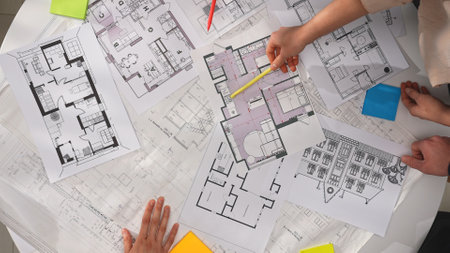 Group of architects, creative interior designers and team members meeting in boardroom at desk,...