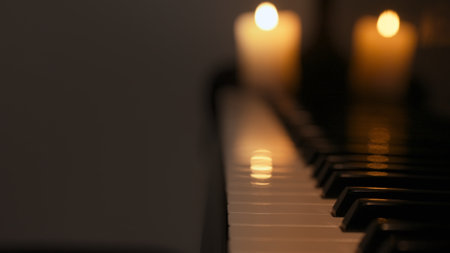Close up shot of black grand piano and candle standing on dark concert stage under low light, isolated on studio background. Instrument for performing in concert hall.の写真素材