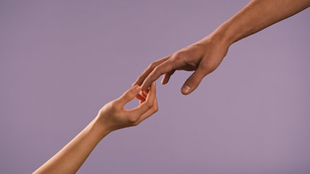 Man and woman hands touching and holding each other, isolated on purple studio background, close up shot. Valentines day advertising concept.の写真素材