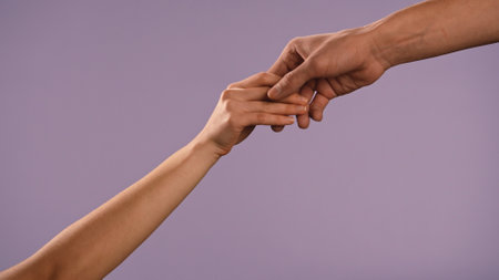 Man and woman hands touching and holding each other, isolated on purple studio background, close up shot. Valentines day advertising concept.の写真素材