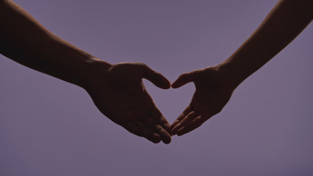 Man and woman hands silhouettes showing gestures, making heart love hand sign, isolated on purple studio background, close up shot. Valentines day advertising concept.の写真素材