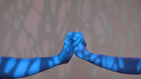 Man and woman hands showing gestures, touching and holding, isolated on studio background with blue light pattern effect, close up shot. Valentines day advertising concept.の写真素材