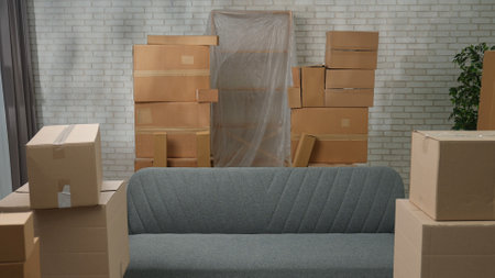 Shot of new apartment, space filled with cardboard boxes and furniture. Interior of new house room with moving stuff in boxes standing in stacks.の写真素材