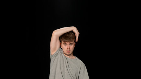Person in light gray clothes dancing hip-hop on black background