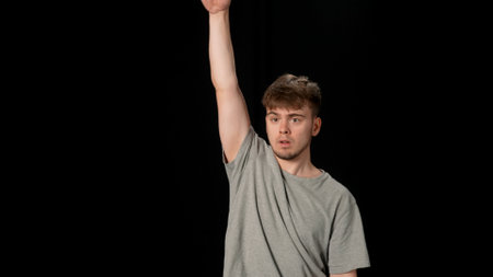Person in light gray clothes dancing hip-hop on black background