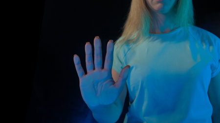 A hand touches glass screen panel, open palm print on transparent surface with blue light. Template for digitalization concept.の写真素材