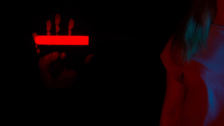 Red light neon access scanner scanning hand print on glass screen panel, open palm print on...