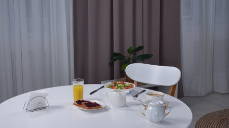 Shot of stylish living room with dining table, freshly prepared meals standing on the table, salad...