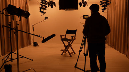 Studio for photo video production filming with lighting equipment and cyclorama, team member setting camera, director chair stand in the middle.の写真素材