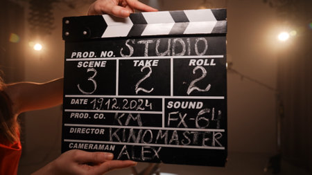 Studio for photo video production filming with lighting equipment and cyclorama, close up of clapperboard with written scene information.の写真素材