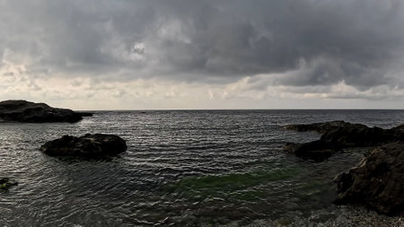Dark clouds over the rocky coast of the Mediterranean Seaの写真素材