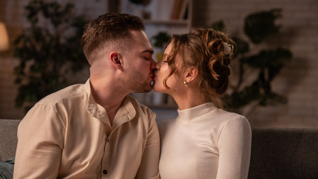 Happy couple celebrating valentines day together at home, man and woman sitting on the sofa and...