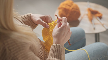 Woman Crocheting with Yellow Yarnの写真素材