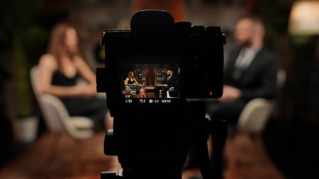 Two experts talking in a cozy, loft-style podcast studioの写真素材