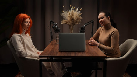 Two Influencers of women being interviewed in a loft-style podcast studioの写真素材