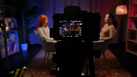 Two Influencers of women being interviewed in a loft-style podcast studioの写真素材