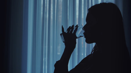 Silhouette of Person Drinking Water in Soft Lightの写真素材