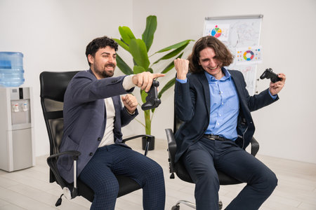Excited Colleagues Playing Video Games During Office Breakの写真素材