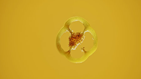 Yellow Pepper Slice Floating on Vibrant Yellow Backgroundの写真素材
