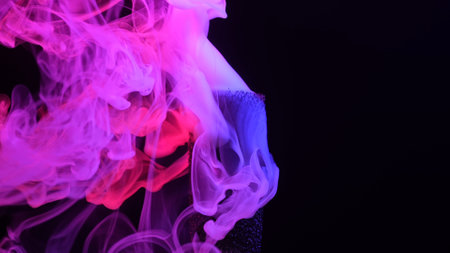 Colorful Pink and Purple Smoke in Dark Backgroundの写真素材