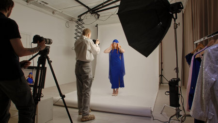 Young adult woman spending time at studio, woman model in fancy outfit taking part in a photoshoot...