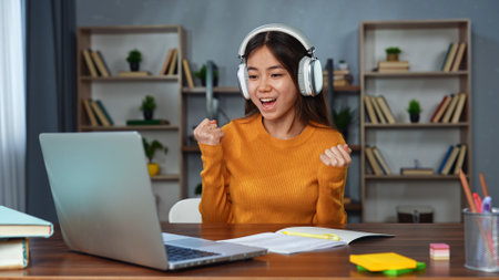 Young Woman Celebrating Success in Online Learning at Homeの写真素材