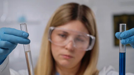 Scientist Examining Test Tubes with Protective Equipment
