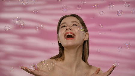 Portrait of Woman with Bubbles and Pink Backgroundの写真素材