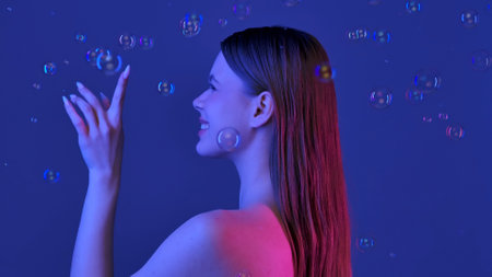 Joyful Woman Surrounded by Floating Soap Bubblesの写真素材