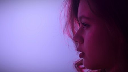 Artistic Portrait of Woman in Soft Purple Lighting Profile View