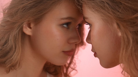 Close-Up Portrait of Two Individuals Facing Each Otherの写真素材