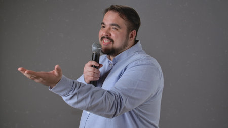 Speaker Engaging Audience with Microphone Presentation Gestureの写真素材