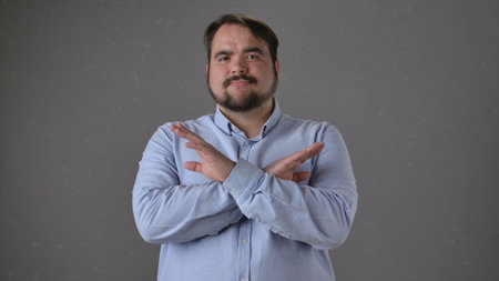 Man Making X Symbol with Arms in a Light Blue Shirtの写真素材