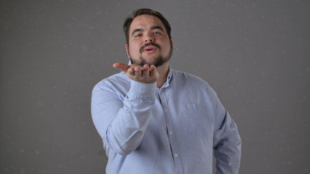 Man in Light Blue Shirt Blowing a Kiss with a Kind Expressionの写真素材