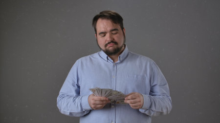 Man Counting Money with Focused Expression Alone