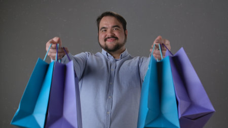 Man Smiling While Holding Colorful Shopping Bags Happily