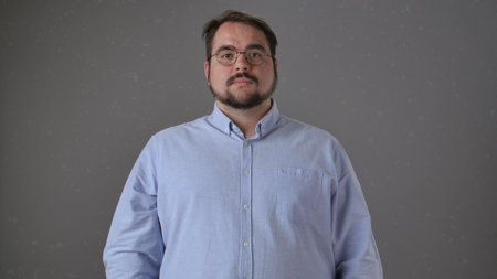 Portrait of a Man in a Light Blue Shirt Against Plain Backgroundの写真素材