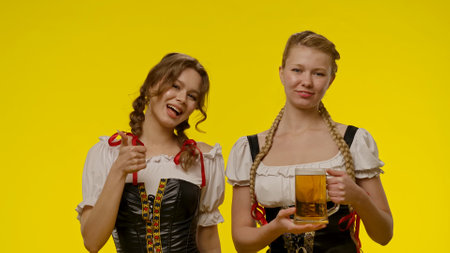 Two Women in Traditional Bavarian Costumes with Beerの写真素材