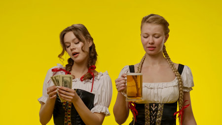 Two women in traditional dresses holding beer mugの写真素材