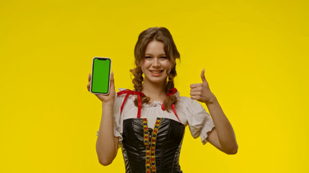 Young Woman Showing Smartphone with Green Screen Displayの写真素材