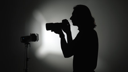 Silhouette of Photographer in Studio with Professional Cameraの写真素材