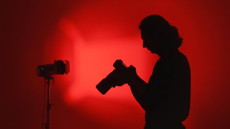 Silhouette of Photographer in Red Light Background Studioの写真素材