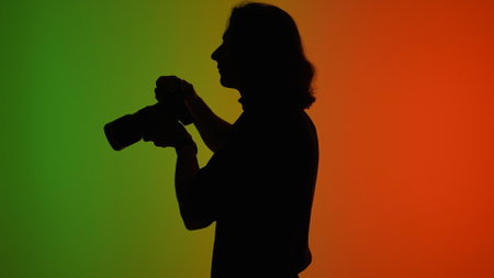 Silhouette of a Photographer Against Colorful Backgroundの写真素材